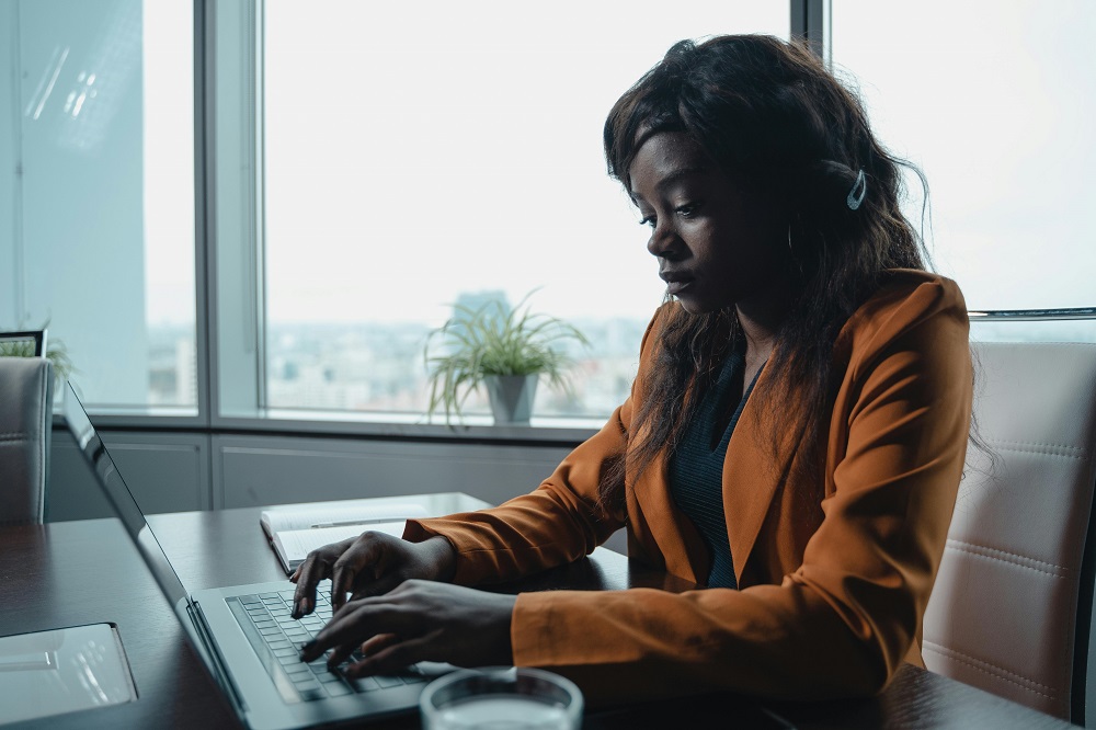 https://www.pexels.com/photo/a-woman-in-an-orange-blazer-typing-on-a-laptop-5717203/